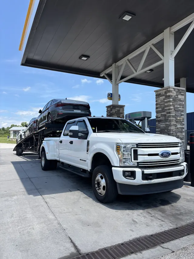 Car hauler at a fuel stop in daylight